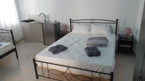 a bedroom with a bed with two towels on it at Stathis Apart 2 in Amorgos +9 photos
