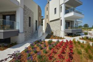 a building with a garden with flowers in it at GreyStoneApartments in Paralia Dionysiou