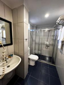 a bathroom with a shower and a toilet and a sink at Club Wasa Holiday Village All Inclusive in Toslak