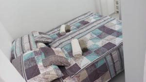 ein Bett mit einer Decke und Kissen darauf in der Unterkunft Panna Apartment Budapest in Budapest