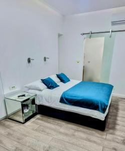 a bedroom with a bed with blue sheets and a glass table at Apartments Lomara in Dubrovnik