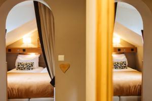 two beds in a room with two mirrors at Coeur des Neiges in Saint-Gervais-les-Bains