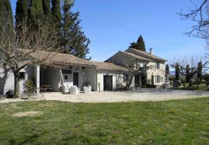 una grande casa bianca con un cortile erboso di La Grange de Marie a Valaurie