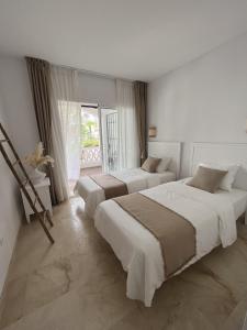 um quarto com 2 camas e uma grande janela em Boutique apartment 365 - Marbella em Marbella