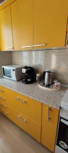 a kitchen with yellow cabinets and a counter top at Central Vanilla Oradea in Oradea
