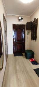 a room with a large wooden door and a green ottoman at Central Vanilla Oradea in Oradea