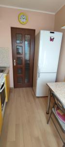 a kitchen with a refrigerator and a clock on the wall at Central Vanilla Oradea in Oradea
