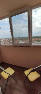 two chairs in a room with two windows at Central Vanilla Oradea in Oradea
