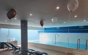 een zwembad in een ruimte met ballonnen aan het plafond bij Hôtel Montaigne & Spa in Cannes