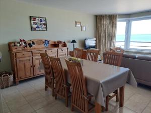 a kitchen and dining room with a table and chairs at Appartement zeedijk Heist met garage in Knokke-Heist