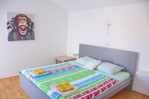 a bedroom with a bed with a painting of a lion at Apartments Summersong in Novalja