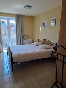 ein Schlafzimmer mit einem Bett in einem Zimmer mit einem Fenster in der Unterkunft Appartement zeedijk Heist met garage in Knokke-Heist