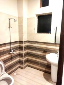 a bathroom with a toilet and a sink at Hotel Royal Sweet in Lahore