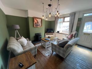 a living room with two couches and a table at Laura Ashley cosy inner terrace in Barnsley