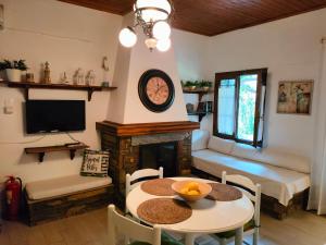 - un salon avec une table et une cheminée dans l'établissement Armonia & Anemos Family Apartments, à Kalamos
