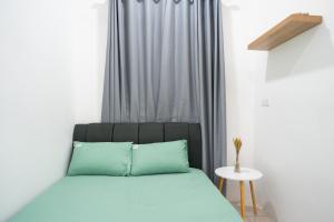 1 cama con almohadas azules en una habitación con ventana en No 19 Studio Homestay (Semi-D), Port Dickson (up to 13 pax) en Port Dickson