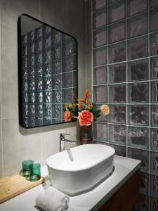 y baño con lavabo blanco y espejo. en Tiny House Phu Quoc, en Phu Quoc