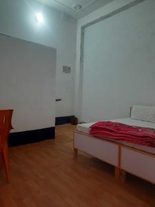 Habitación blanca con cama y suelo de madera. en OYO HOME 80891 Hotel Always Welcome en Jewar