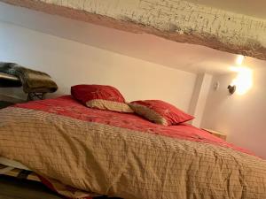 Loft Casa Wi hyper centre - Parking-clim في بيربينيا: غرفة نوم مع سرير مع وسادتين حمراء