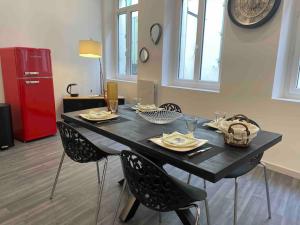 czarny stół z krzesłami i czerwona lodówka w obiekcie Loft Casa Wi hyper centre - Parking-clim w Perpignanie
