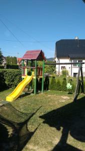 a playground with a yellow slide in a yard at Kipi Casa Family Apartment 3+2 with living room in Lazany