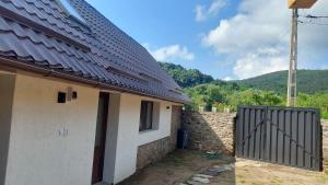 ein Haus mit einem Tor und einem Zaun in der Unterkunft Casa nouă in Sasca Montană