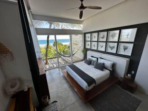 a bedroom with a bed with a view of the ocean at TULUM Beachfront Villa I'Ik by Casa Xuul Tulum in Tulum +80 photos