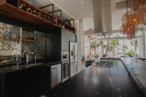 a kitchen with a black counter top in a room at TULUM Beachfront Villa I'Ik by Casa Xuul Tulum in Tulum