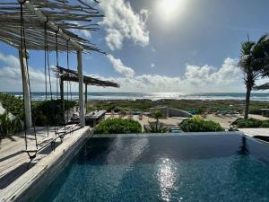 a swimming pool with a view of the beach at TULUM Beachfront Villa I'Ik by Casa Xuul Tulum in Tulum