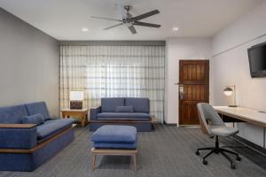 a living room with two blue couches and a tv at Courtyard Santa Fe in Santa Fe