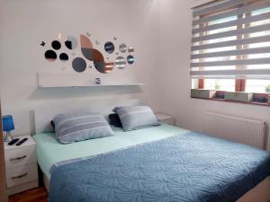 a bedroom with a bed with two pillows and a window at Apartman Teo in Lukavica