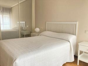 1 dormitorio con cama blanca y espejo en Céntrico apartamento de 2 habitaciones by beBalmy, en Oviedo