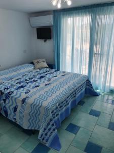 a bedroom with a bed with a blue comforter at Villa la Torre Levante in Torre Dei Corsari