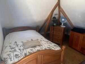 a bed with a wooden frame with a pillow on it at De oude paardentramremise in Ulrum