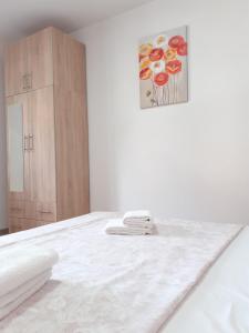 a white room with a bed and a painting on the wall at Apartman Prenj in Konjic