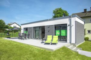 a patio with chairs and tables in a yard at Pension Fiets in Großmehring