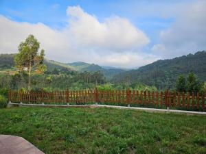 a wooden fence with a view of a mountain at 201A La Huerta de Cayao in Villaviciosa