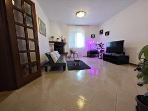 a living room with a couch and a television at Charlie's Home Arezzo-Appartamento-B&B Arezzo con Parcheggio privato- Arezzo Città del Natale 2023 - Centro Arezzo Fiere e Congressi- Mercatini Natale Arezzo Casa di Babbo Natale e Villaggio Tirolese 2023 in Arezzo