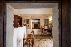 a kitchen with a counter and a table and chairs at Agriturismo Masseria Costarella in Borgagne