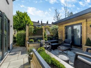 a backyard patio with chairs and a table at Squirrel Cottage in Glossop