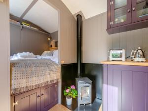 a bedroom with a bed and a stove in a room at Annie - Uk44003 in Cold Kirby