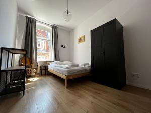 a bedroom with two beds and a black cabinet at BISCHOFSBERG Gdańsk City Center Apartments in Gdańsk