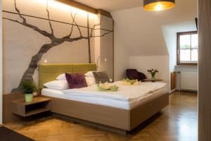 ein Schlafzimmer mit einem Bett mit einem Baumbild an der Wand in der Unterkunft Weingut Ferdl Denk in Weissenkirchen in der Wachau