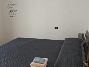 a bedroom with a bed with a blue towel on it at Charlie's Home Arezzo-Appartamento-B&B Arezzo con Parcheggio privato- Arezzo Città del Natale 2023 - Centro Arezzo Fiere e Congressi- Mercatini Natale Arezzo Casa di Babbo Natale e Villaggio Tirolese 2023 in Arezzo