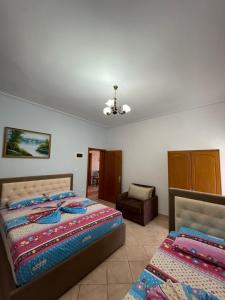 1 dormitorio con 2 camas y 1 silla en Garden Villa Veli en Ksamil