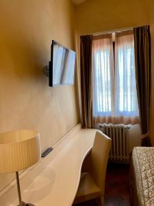 Villa dei Tigli 920 Liberty Resort في Rodigo: غرفة مع طاولة وتلفزيون على الحائط