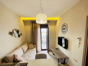 ein Wohnzimmer mit einem Sofa und einem Tisch in der Unterkunft Yulia Luxury Apartment in Ouranoupoli