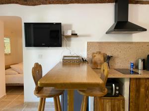 une cuisine avec une table en bois et deux chaises dans l'établissement Les Sources, à Fontaine-de-Vaucluse