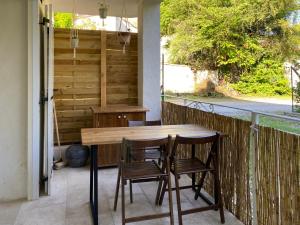 Une table et des chaises en bois sont disponibles sur la terrasse. dans l'établissement Les Sources, à Fontaine-de-Vaucluse