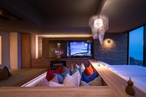 a bedroom with a large bed with colorful pillows at Tara Dakeonsen Kanigoten in Tara